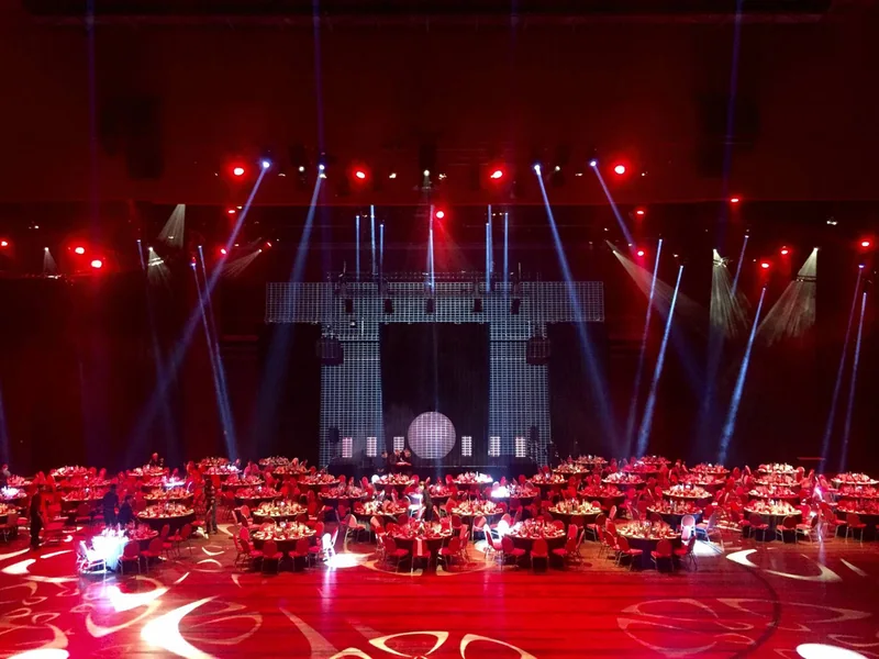 Salle de gala scénographiée en rouge avec écrans et lasers